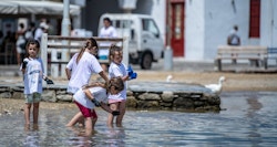 3 children in the water in tee shirts